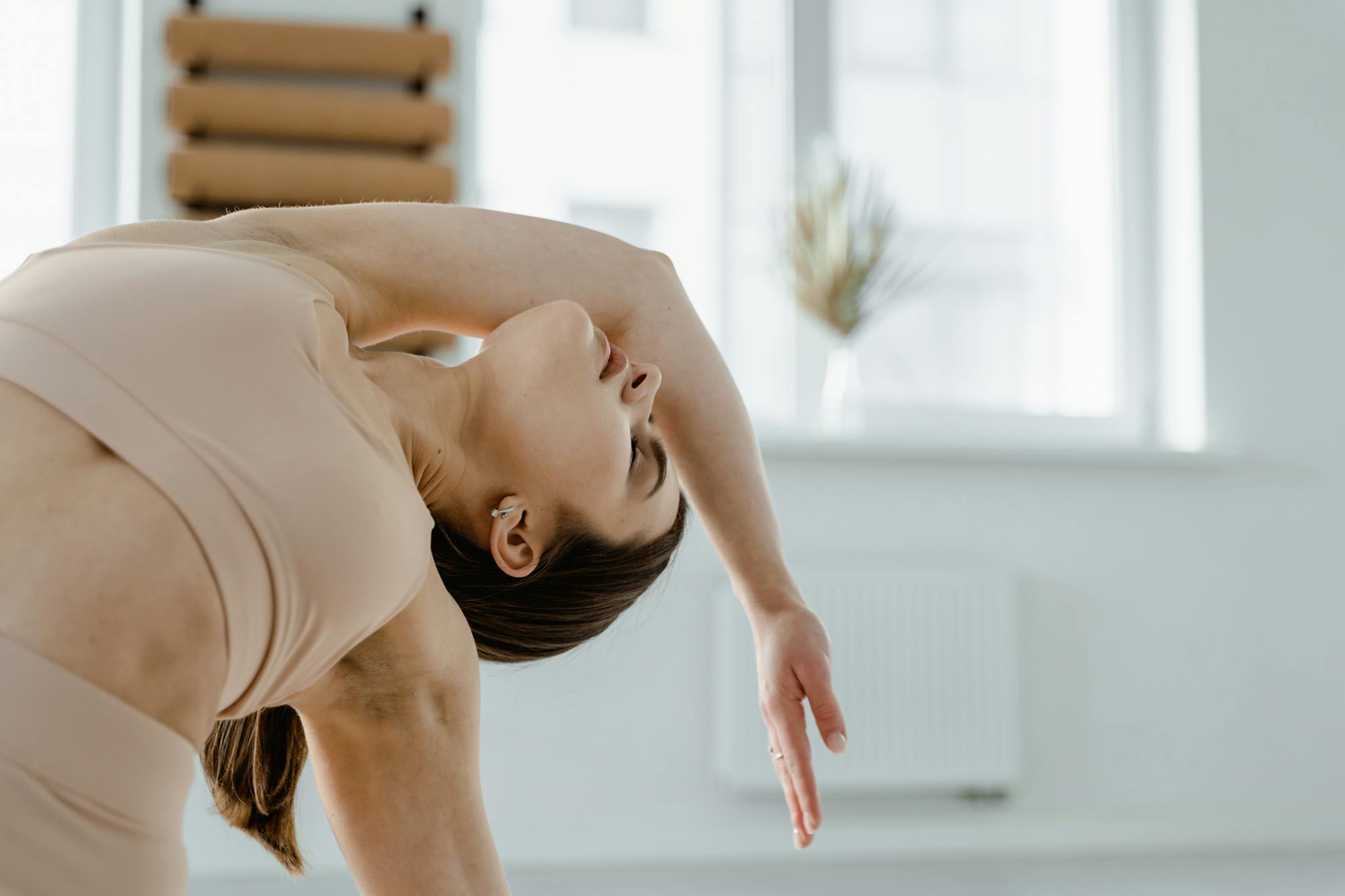 Woman in sportswear practicing yoga indoors, emphasizing flexibility and grace.